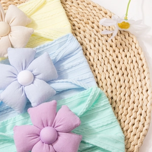 Gros plan de bandeaux bébé en maille côtelée avec fleurs 3D aux couleurs macaron