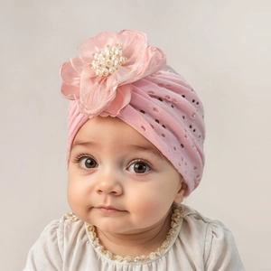 Detail eines rosa Babyturbans mit atmungsaktivem Mesh und großer Organzablüte mit Perlen