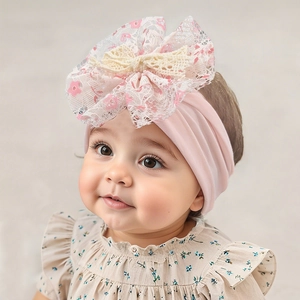 Detailed close-up of a baby girl wearing a soft floral lace bow nylon headband