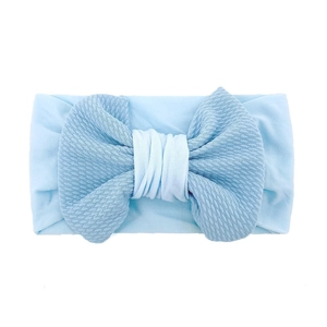Detailed view of light blue waffle fabric texture and oversized bow on baby headband