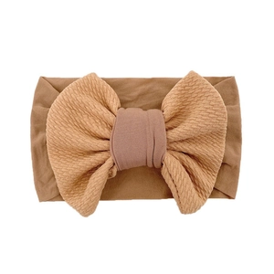 Close-up of caramel brown baby headband with ribbed texture bow and soft fabric