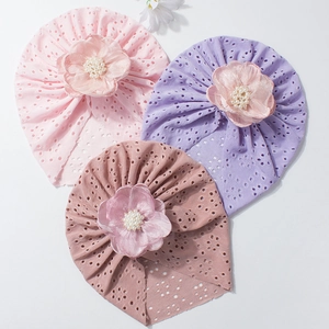 Drei hohle Strickmützen für Babys mit großen Tüllblumen und Perlenperlen
