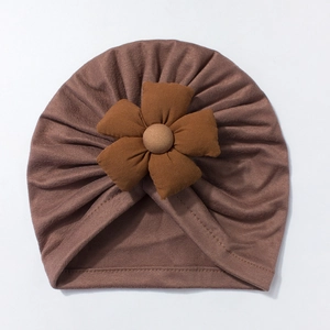 Detailed view of dark brown baby turban hat with a large 3D fabric flower and soft texture