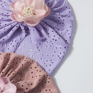 Detail von Baby Turban-Mützen mit Lochstrickmuster und großen 3D-Blumen mit Perlen