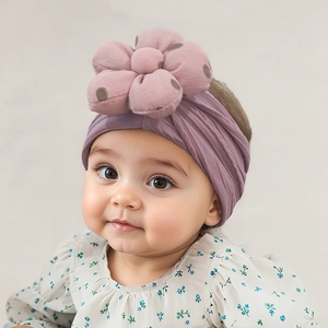 Detailaufnahme von lila Baby-Stirnband aus Strick mit gepunkteter Stoffblume als Ornament