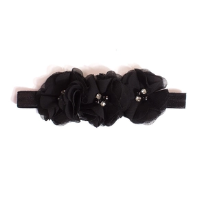 Dettaglio di fiori in chiffon nero con strass su una fascia elastica per bambini
