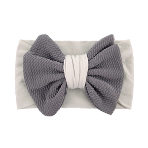 Detail of baby headband featuring soft grey waffle texture fabric and large bow design