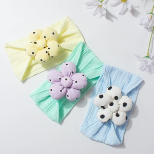 Three-piece baby headband set with polka dot flower details in yellow green and blue