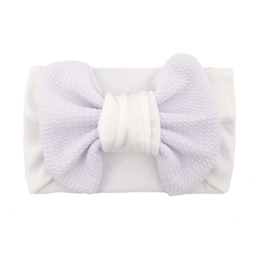 Detailed macro view of large lavender honeycomb textured bow on white elastic baby headband