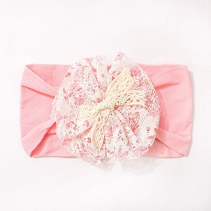 Detail of pink floral lace and off-white hollow lace bow on soft elastic baby headband