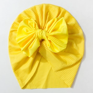 Close-up of mustard yellow ribbed knit baby turban hat with a large bow detail