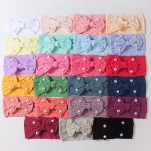 Collezione di 19 fasce per neonati colorate con fiocchi e perle su sfondo bianco