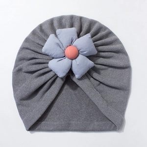 Detail of soft grey baby turban hat featuring a light blue fabric flower with pink center