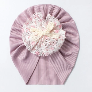 Vue détaillée du bonnet turban bébé côtelé avec fleur en dentelle et petit nœud