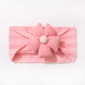 Détail d'un bandeau rose côtelé pour bébé avec nœud floral en tissu doux pour nouveau-nés