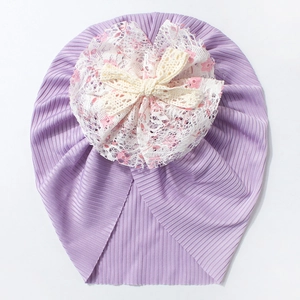 Détail du turban violet pour bébé avec fleurs en dentelle et nœud en crochet doux