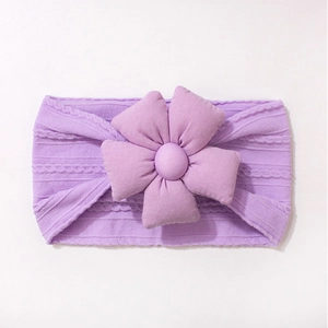 Détail du tissage du bandeau violet pour bébé avec une fleur en tissu 3D et un bouton