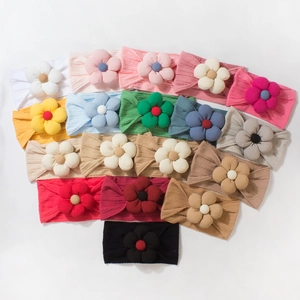 Soft ribbed baby headbands with large fabric flower decorations in multiple colors