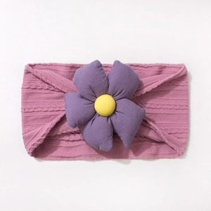 Gros plan du bandeau bébé en maille côtelée rose avec une grande fleur 3D violette et jaune