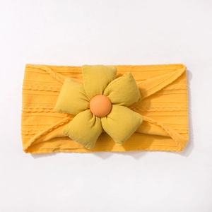 Détail d'un bandeau pour bébé en tricot côtelé doux avec grande fleur en tissu orange