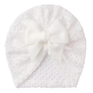 Detailed view of soft waffle knit texture on baby turban hat with large bow decoration