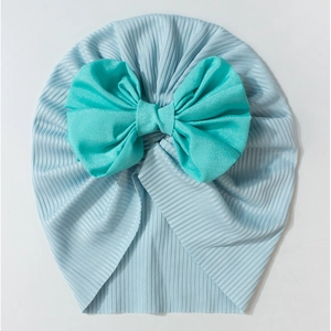 Soft ribbed baby turban hat in light blue featuring a large mint green bow decoration