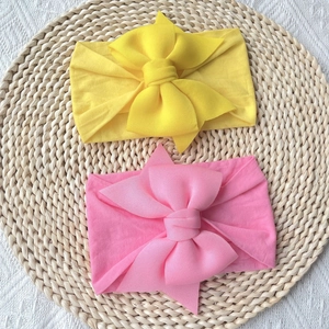 Soft nylon baby headbands with large bows in bright yellow and pink colors for newborns