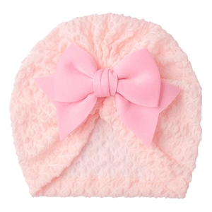 Detail view of pink baby hat with bubble texture fabric and a large bow decoration