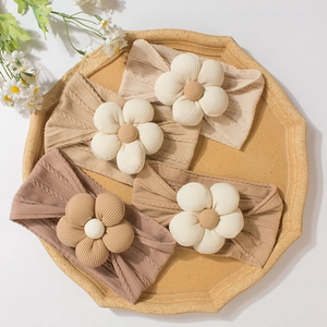 Set of four infant flower headbands in neutral tones with vintage knit texture
