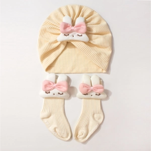 Vue détaillée du kit bonnet et chaussettes bébé beige avec tête de lapin et ruban rose