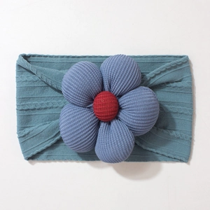 Close-up of baby headband featuring soft cable knit texture and 3D jacquard flower detail