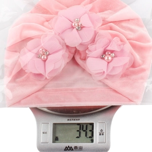 Turbant rose en velours pour bébé affichant un poids léger de 34,3g sur balance