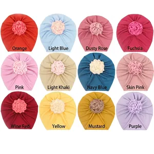 Flat lay of baby turban hats in 12 assorted colors featuring handmade rose flowers