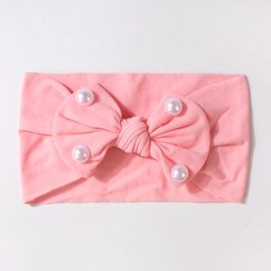 Dettaglio fascia per neonati rosa con fiocco e perle bianche decorative di alta qualità
