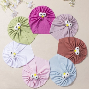 Détail de huit bonnets bébé en coton côtelé colorés avec un design mignon d'yeux de monstre