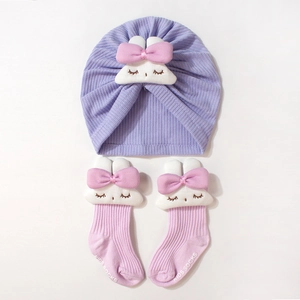 Détail du bonnet turban bébé en tricot gaufre mauve et chaussettes roses avec lapins