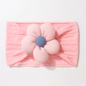 Detail of pink knitted baby headband with a large striped 3D flower and blue center