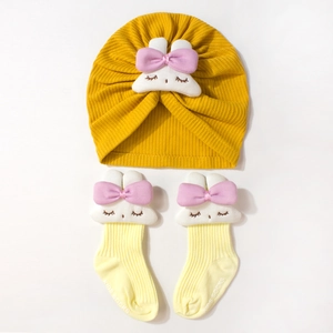 Détail du lot bonnet et chaussettes pour bébé en maille côtelée avec lapins blancs