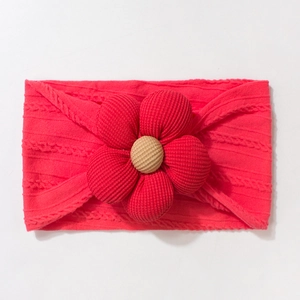 Close-up of bright red knitted baby headband featuring a large floral 3D jacquard decoration