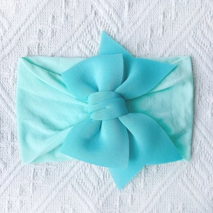 Detailed close-up of a mint green soft nylon baby headband with a large layered bow knot