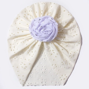 Détail du bonnet turban bébé en tricot ajouré avec fleur lavande et tissu respirant