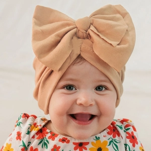 Close-up of camel knit cotton baby turban featuring a large decorative bow detail