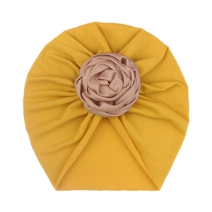 Infant yellow turban hat featuring a large champagne satin rose flower decoration