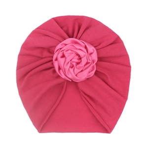 Close-up of deep pink baby turban with detailed satin rose flower embellishment