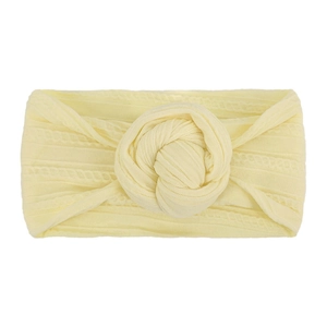 Dettaglio di una fascia per neonati in nylon giallo pallido con nodo a forma di ciambella