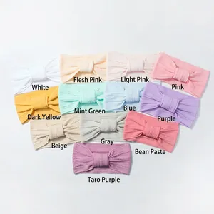 Flat lay display of 11 stretch nylon baby headbands in various solid pastel colors