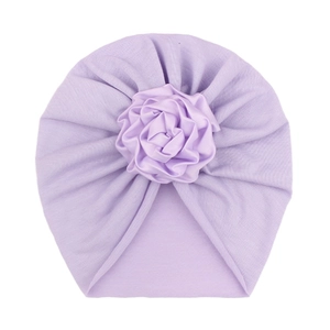 Detail view of a soft lavender infant turban hat with a large handmade floral rose decoration