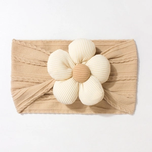 Close-up of khaki knitted baby headband with a 3D floral accent and soft cable weave