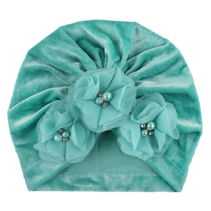 Vue détaillée du turban pour bébé en velours avec fleurs en mousseline et perles
