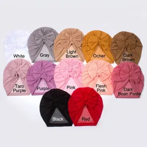 Flat lay collection of twelve colorful mesh bow turbans for babies in diverse pastel shades